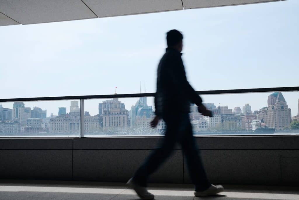 Modern Cityscape View Of A Businessman Walking In An Urban Environment, Emphasizing Professional Growth And Construction Industry Opportunities.
