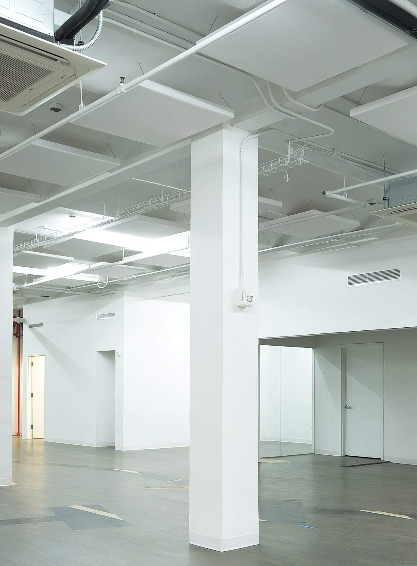 Modern Commercial Interior With White Walls, Exposed Ceilings, And Seamless Flooring, Ideal For Professional Office Spaces And Building Projects By American Builders.