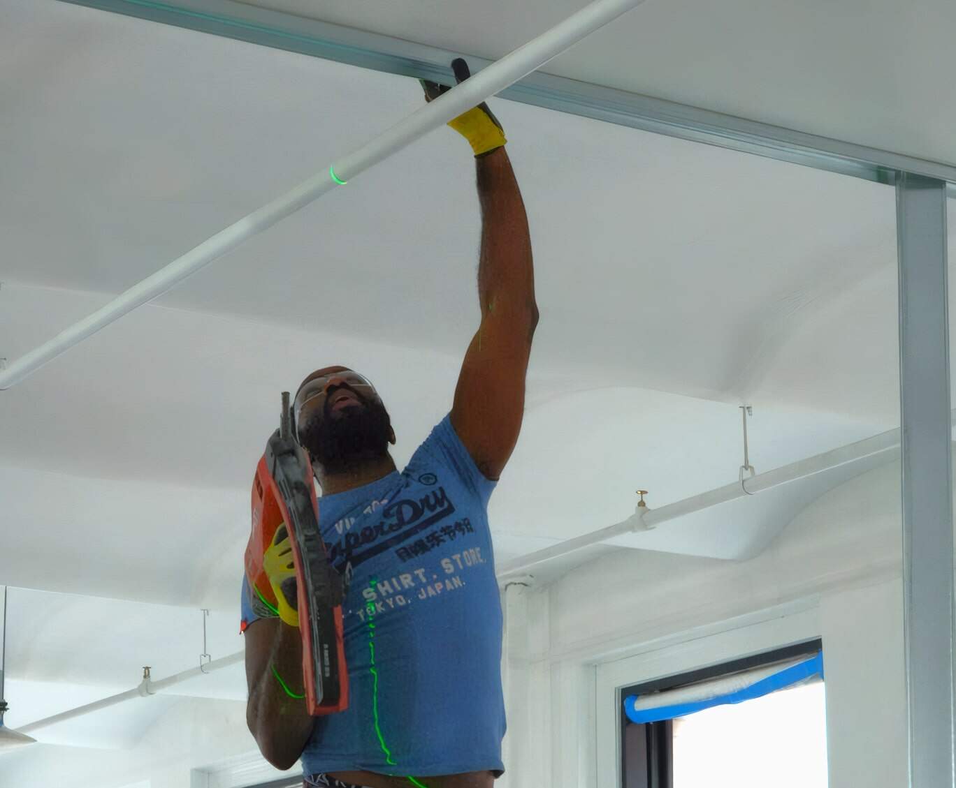 Electrical Worker Installing Ceiling Fixtures At A Construction Site, Showcasing Professional Skills And Safety Measures.