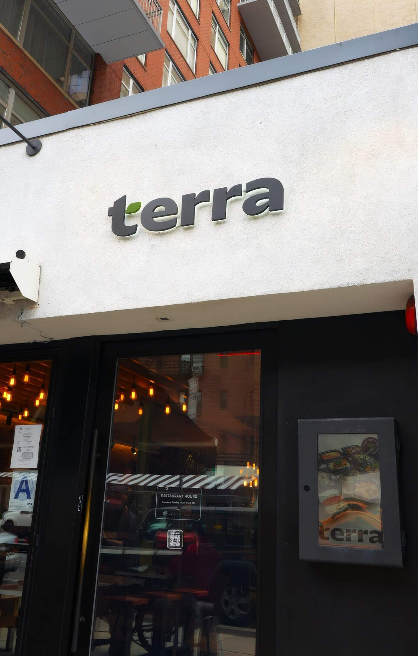 Terra Restaurant Exterior Sign, Modern Building Facade, Contemporary Dining Establishment, Urban Restaurant Design, Trendy Eatery Entrance, Focus On Restaurant Branding And Building Architecture.